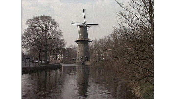 Windmills on a dyke in Holland. The Rich Tradition: Holland